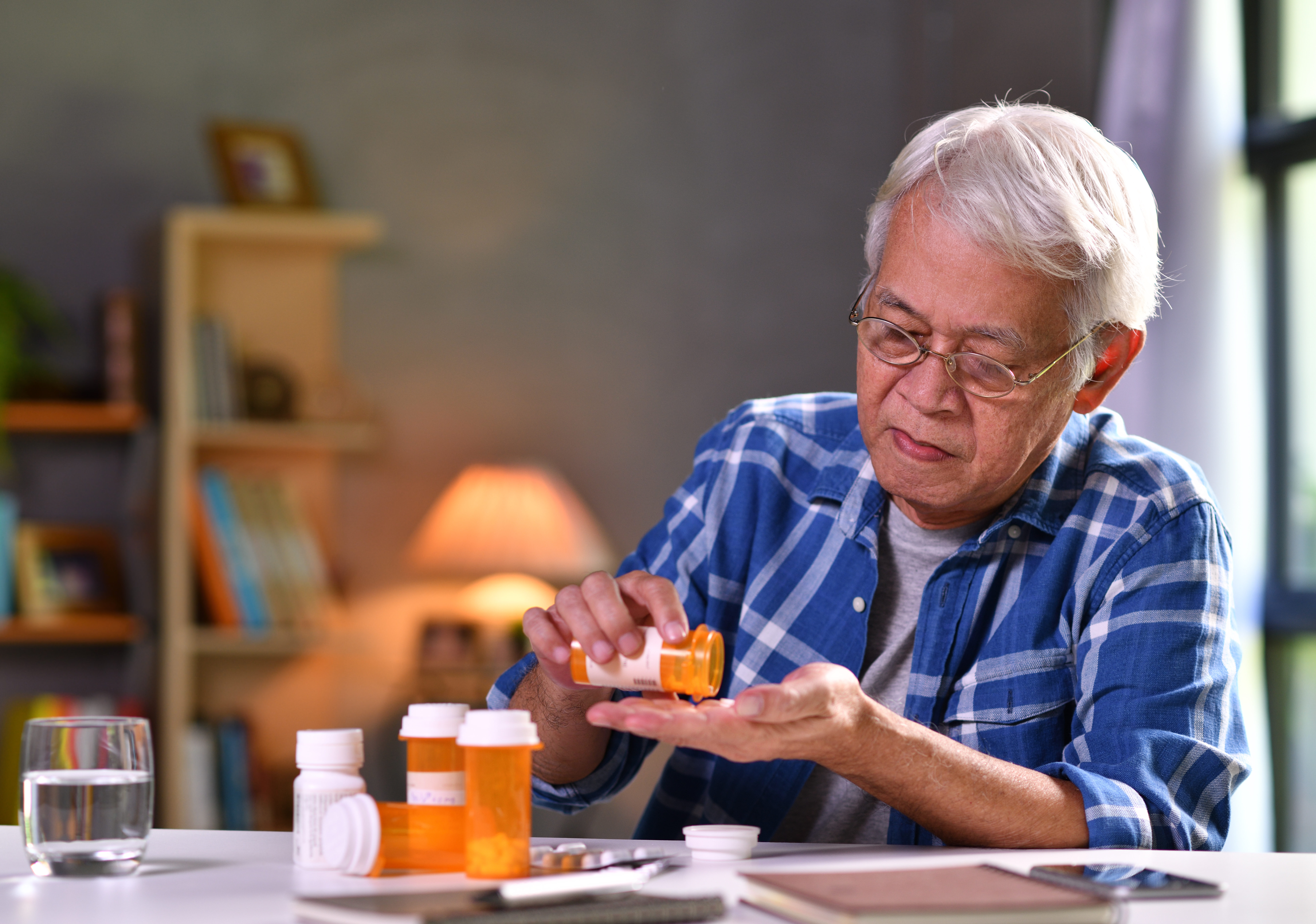 Asian senior man taking medicine at home